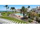Beautiful view of a community pool, lawn, and beach with chairs, palm trees, lounge seating, and lovely landscaping at 1445 Gulf Of Mexico Dr # 203, Longboat Key, FL 34228