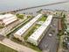An aerial view of the condo community, showcasing lush greenery, a pool, parking, and waterfront access with a bridge nearby at 150 Harborside Ave # 307, Punta Gorda, FL 33950