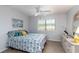 Sunlit bedroom features calming decor, complemented by a ceiling fan and white dresser under a bright window at 150 Harborside Ave # 307, Punta Gorda, FL 33950