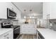 A well-lit kitchen features stainless steel appliances and white cabinetry extending into the combined living/dining area at 150 Harborside Ave # 307, Punta Gorda, FL 33950