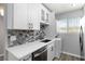 This laundry room has a modern gray backsplash, white cabinets, and stainless steel appliances at 150 Harborside Ave # 307, Punta Gorda, FL 33950