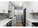 This laundry room has a modern gray backsplash, white cabinets, and stainless steel appliances at 150 Harborside Ave # 307, Punta Gorda, FL 33950