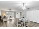 The living room includes stylish dining set, modern chandelier and fan, with a sliding door to the outside patio at 150 Harborside Ave # 307, Punta Gorda, FL 33950