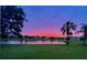 Beautiful backyard pond view with lush lawn and lovely sunset at 1539 Ormond Ter, Parrish, FL 34219