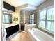 Bright bathroom featuring a soaking tub, glass enclosed shower, and a vanity with ample storage at 1539 Ormond Ter, Parrish, FL 34219