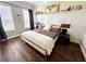Comfortable bedroom featuring a king bed, wood floor, and natural light through the windows at 1539 Ormond Ter, Parrish, FL 34219