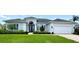 Charming single-story home with a well-manicured lawn, complemented by lush landscaping and a two-car garage at 1539 Ormond Ter, Parrish, FL 34219