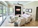 Spacious living room with large windows, a built-in entertainment center, and luxurious white furniture at 1539 Ormond Ter, Parrish, FL 34219