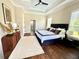Spacious main bedroom featuring a tray ceiling, dark wood floors, and elegant furnishings at 1539 Ormond Ter, Parrish, FL 34219