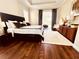 Warm and inviting main bedroom featuring a king bed, hardwood floors, and a decorative rug at 1539 Ormond Ter, Parrish, FL 34219