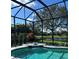 A crystal-clear pool in a screened enclosure has a view of the green landscape at 1539 Ormond Ter, Parrish, FL 34219
