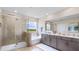 Bright bathroom with a separate tiled shower, tub, double vanity, and a large mirror at 17924 Tavernside Trl, Bradenton, FL 34211