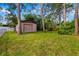 View of backyard and storage shed/small garage, surrounded by mature trees at 1862 Rita St, Sarasota, FL 34231