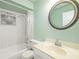 Inviting bathroom with white tiled walls, a round mirror, and a classic vanity at 1862 Rita St, Sarasota, FL 34231