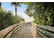 Picturesque wooden boardwalk leading to the beach, surrounded by lush tropical vegetation at 1862 Rita St, Sarasota, FL 34231