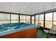 Enclosed hot tub room featuring an in-ground hot tub, chairs, and natural lighting at 1862 Rita St, Sarasota, FL 34231
