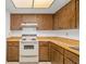 Kitchen with light countertops, wood cabinets, and an electric stove at 1862 Rita St, Sarasota, FL 34231