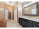 Well-lit bathroom featuring a dark vanity, marble countertop, and a large mirror above the sink at 18620 Cortes Creek Blvd, Spring Hill, FL 34610