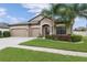 Well-maintained single-story home featuring a three-car garage, lush lawn, and attractive shrubbery at 18620 Cortes Creek Blvd, Spring Hill, FL 34610