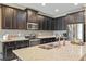 Modern kitchen featuring stainless steel appliances, granite countertops, and ample dark wood cabinetry at 18620 Cortes Creek Blvd, Spring Hill, FL 34610