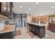 A well-equipped kitchen with dark wood cabinets, stainless steel appliances, a kitchen island, and an adjacent dining area at 18620 Cortes Creek Blvd, Spring Hill, FL 34610