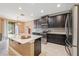Modern kitchen featuring dark wood cabinets, stainless steel appliances, quartz countertops and an island at 18620 Cortes Creek Blvd, Spring Hill, FL 34610