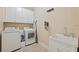 Functional laundry room featuring a washer, dryer, utility sink, and overhead cabinets for ample storage at 18620 Cortes Creek Blvd, Spring Hill, FL 34610