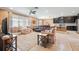 Bright living room with neutral tones, featuring a ceiling fan, large windows, and open access to the kitchen at 18620 Cortes Creek Blvd, Spring Hill, FL 34610
