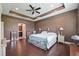Spacious main bedroom with a tray ceiling, ceiling fan, and hardwood floors at 18620 Cortes Creek Blvd, Spring Hill, FL 34610