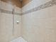 Tiled shower featuring a rainfall shower head and decorative accent tiles at 18620 Cortes Creek Blvd, Spring Hill, FL 34610
