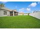 View of the well-maintained backyard, complemented by a screened-in patio and a white fence at 1905 Via Napoli St, Plant City, FL 33566