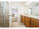 Bright bathroom featuring a double sink vanity, walk-in shower and an open view of a bedroom at 1905 Via Napoli St, Plant City, FL 33566