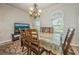 Dining room with a chandelier, a large window, and a dining table with a lace tablecloth at 1905 Via Napoli St, Plant City, FL 33566
