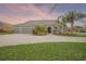 Charming home featuring a three-car garage, a well-manicured lawn, and tropical landscaping at 1905 Via Napoli St, Plant City, FL 33566