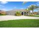 Charming home featuring a three-car garage, a well-manicured lawn, and tropical landscaping at 1905 Via Napoli St, Plant City, FL 33566