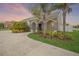 Home exterior features a covered entry way, lush landscaping, and a concrete driveway at 1905 Via Napoli St, Plant City, FL 33566
