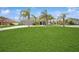 Wide shot of house showcasing lush lawn, palm trees, and a three-car garage at 1905 Via Napoli St, Plant City, FL 33566