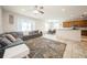 Open-concept living room with a plush area rug and adjacent dining area with ample sunlight at 1905 Via Napoli St, Plant City, FL 33566