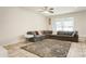 Living room with tile floors, a ceiling fan, large sliding glass doors, and a cozy sectional couch at 1905 Via Napoli St, Plant City, FL 33566