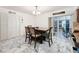 Bright dining room with marble floors, a wooden table with four chairs, and sliding glass doors at 2214 Elise Marie Dr, Seffner, FL 33584