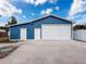 Front-facing view of the blue garage with two white entry doors and a white roll-up garage door at 2214 Elise Marie Dr, Seffner, FL 33584