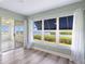 Bright bedroom featuring large window, neutral paint, and sliding glass door to balcony, and ceiling fan at 2424 Placida Rd # D102, Englewood, FL 34224