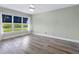 Bedroom with large window overlooking water, neutral paint, ceiling fan, and light wood-look flooring at 2424 Placida Rd # D102, Englewood, FL 34224