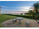 Exterior shot of property with a stone table set and beautiful sunset views of the water at 2424 Placida Rd # D102, Englewood, FL 34224