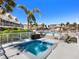 Community hot tub with surrounding lounge chairs and umbrellas to relax and enjoy the Florida sun at 2424 Placida Rd # D102, Englewood, FL 34224