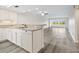 Modern kitchen with white cabinets and stainless steel sink, opening to the living area at 2424 Placida Rd # D102, Englewood, FL 34224