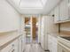 Bright white kitchen leads to outdoor balcony, featuring matching appliances and counterspace at 2424 Placida Rd # D102, Englewood, FL 34224