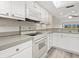 Bright kitchen featuring modern appliances, light cabinetry, and a view into the living room at 2424 Placida Rd # D102, Englewood, FL 34224