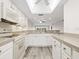 Open kitchen with white cabinets, updated appliances, and a view into the adjacent living space at 2424 Placida Rd # D102, Englewood, FL 34224