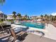 Community pool area with lounge chairs and palm trees, creating a relaxing and inviting atmosphere at 2424 Placida Rd # D102, Englewood, FL 34224
